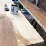 Kitchen worktop staining in progress with a can of stain and a brush.