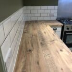 Modern kitchen design with wooden countertops and white subway tile backsplash.