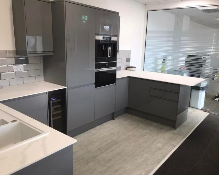 Modern kitchen with grey cabinets, built-in appliances, and elegant kitchen tiling.