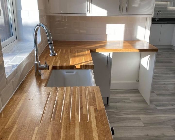 Modern kitchen design with wooden countertops and stainless steel sink.