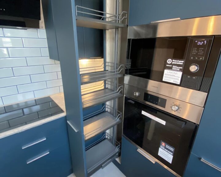 Modern kitchen with stainless steel appliances and kitchen tiling featuring an open corner pull-out storage system.