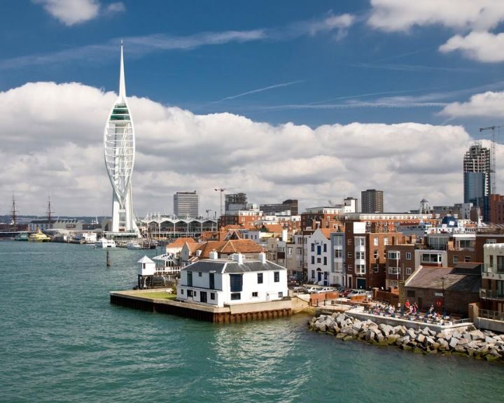 Portsmouth skyline featuring the Spinnaker Tower and kitchen design-inspired waterfront buildings on a partly cloudy day.