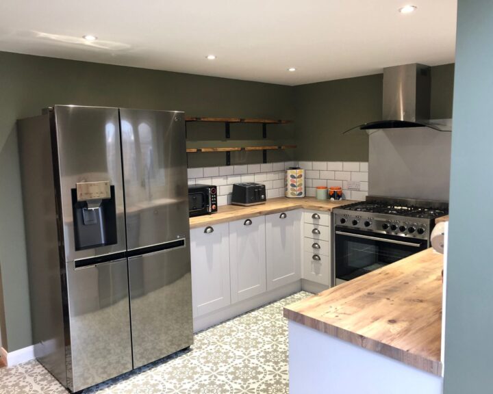 Modern kitchen design with stainless steel appliances, white cabinetry, and patterned floor tiles.