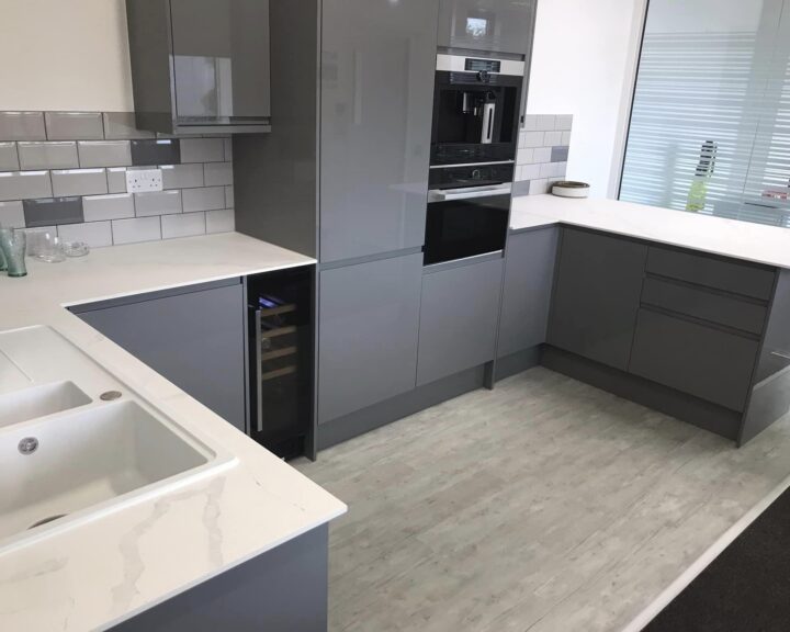 Modern kitchen with grey cabinets and white countertops.